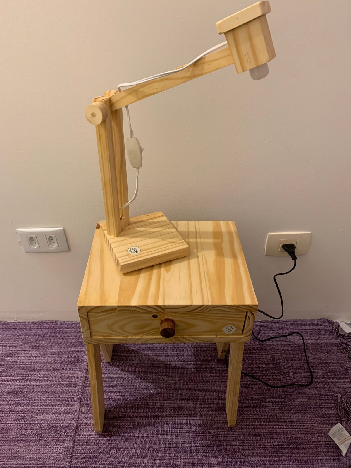 Luminária articulada em madeira sobre banco